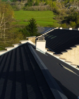 Toiture en tuiles métalliques anthracite face aux prairies du Vercors